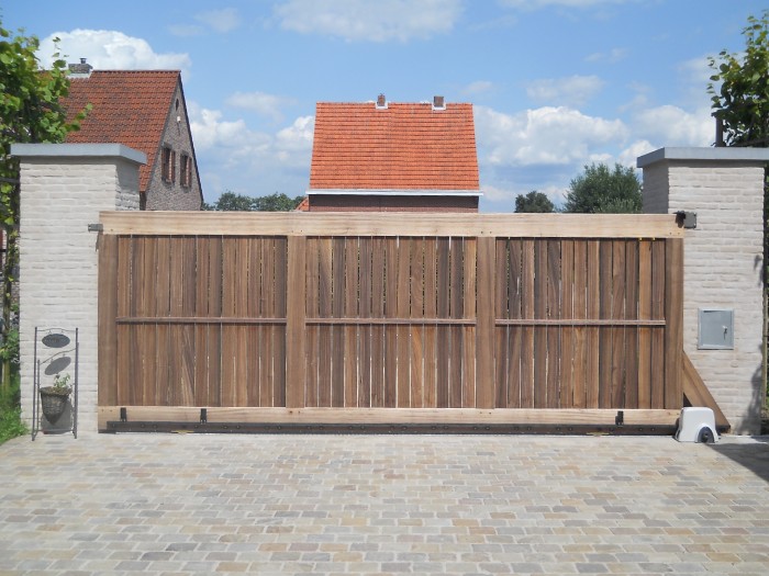 Maatwerk houten poort in Eindhoven met schuivende constructie tussen gemetselde kolommen